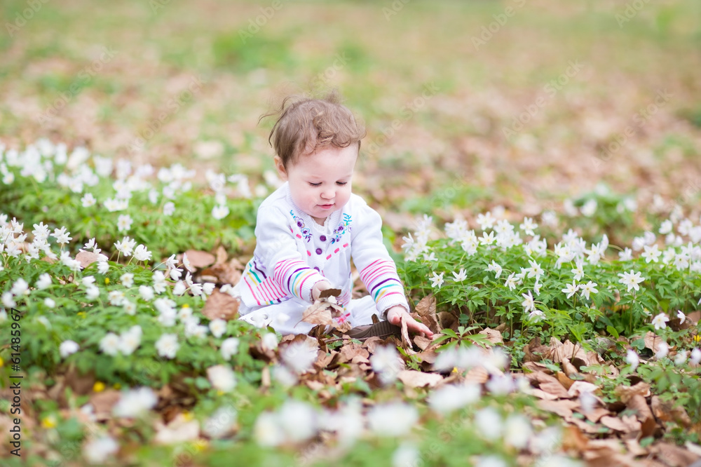 Little funny girl playing with the first spring flowers Little funny girl playing with the first spring flowers