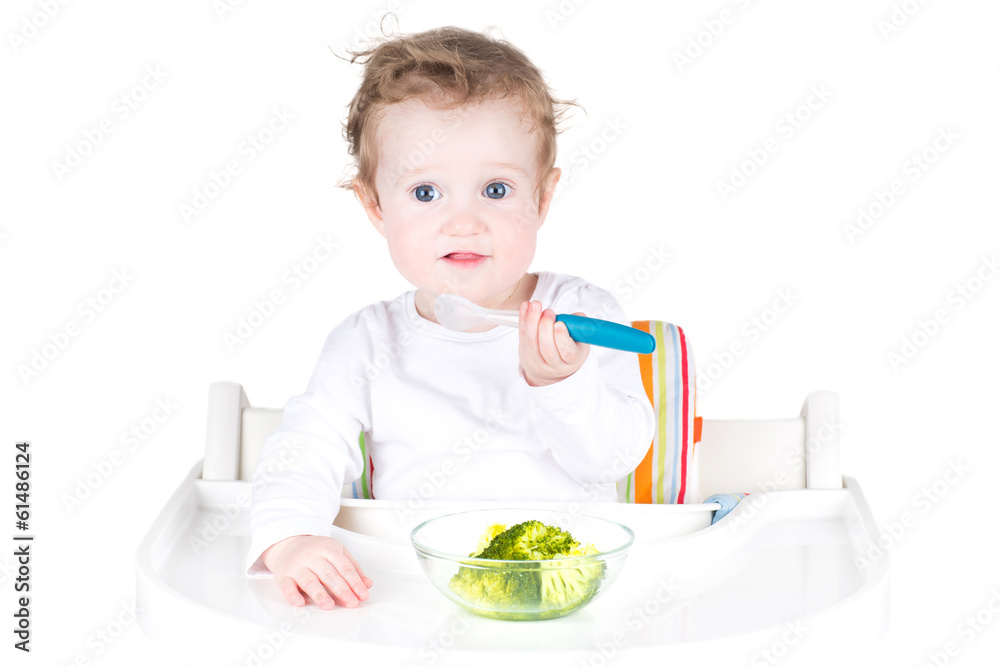 Cute baby with big blue eyes having broccoli for lunch Cute baby with big blue eyes having broccoli for lunch