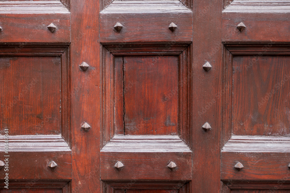 Wood and metal door with metallic spikes looking worn and grungy