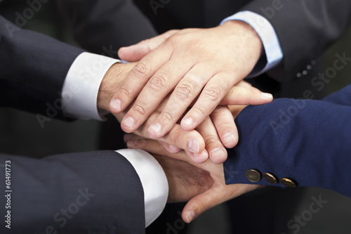 Businesspeople hands on top of each other as symbol of their uni