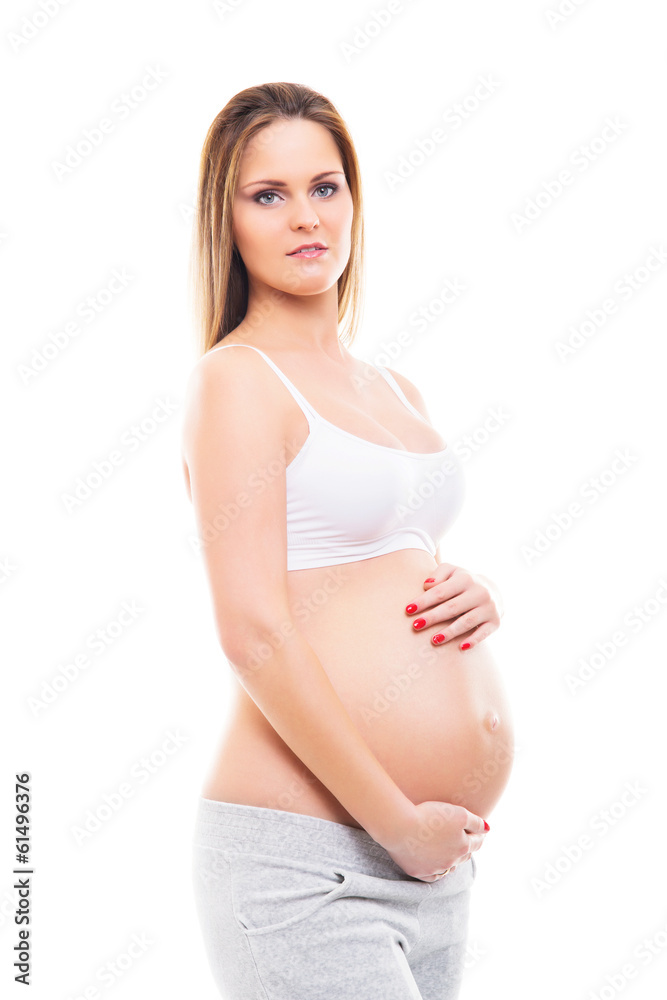 A young blond pregnant woman in white sporty clothes A young blond pregnant woman in white sporty clothes