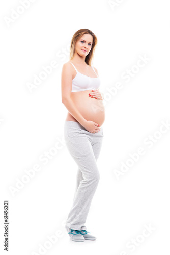 A young blond pregnant woman in white sporty clothes