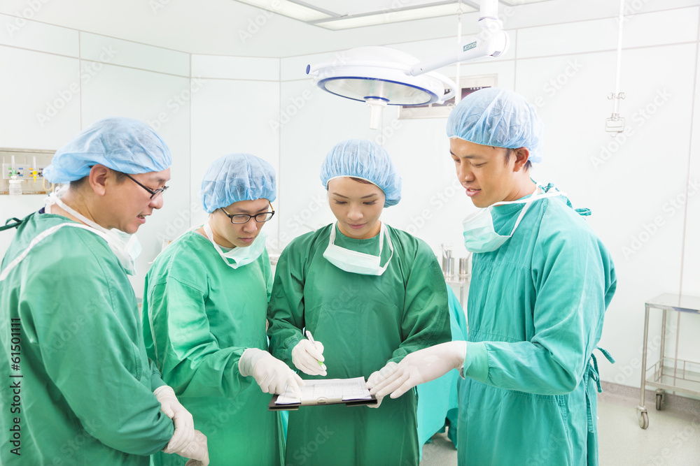 surgeons discussing about something in operating theater