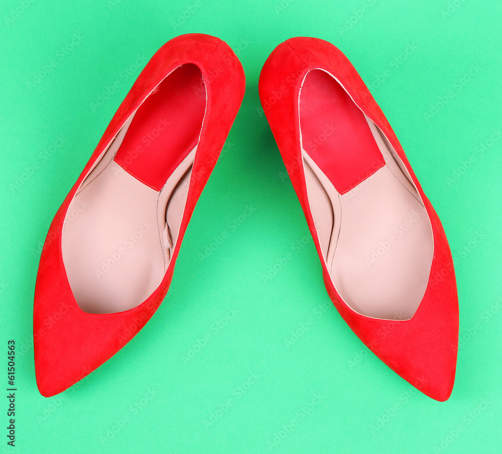 Beautiful red female shoes, on green background Beautiful red female shoes, on green background
