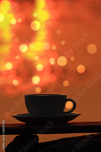 Morning coffe cup on wooden board with bokeh background