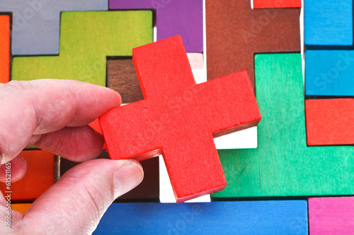 putting cross shaped block in wooden puzzle