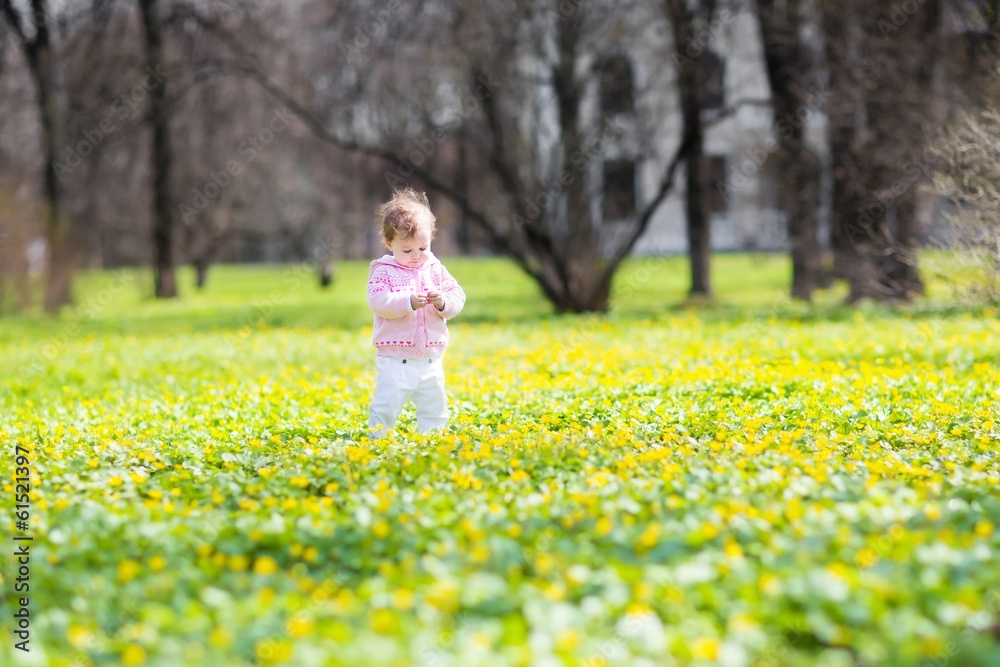 Little baby girl walking among yellow flowers Little baby girl walking among yellow flowers