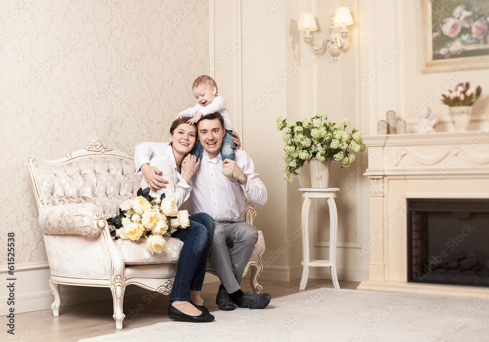 Obraz premium Young happy family with a baby indoors