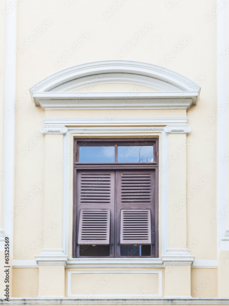 wooden window with shutters open on light yellow wall wooden window with shutters open on light yellow wall