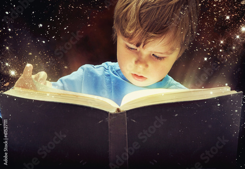 Amazed young boy with magic book