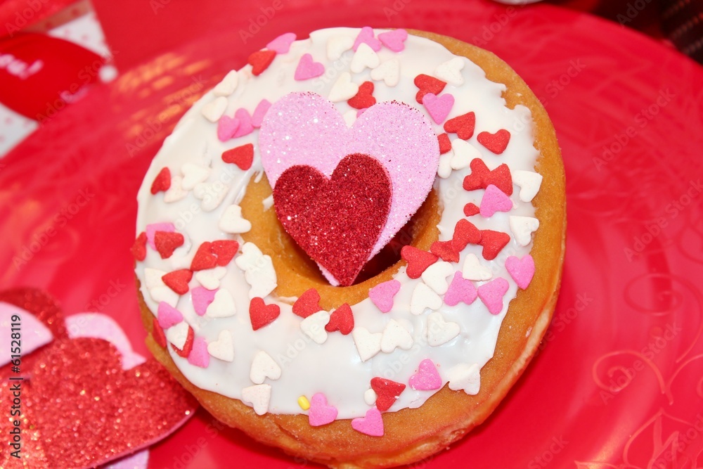 White frosted donut with heart sprinkles White frosted donut with heart sprinkles