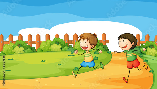 Two boys playing inside the wooden fence