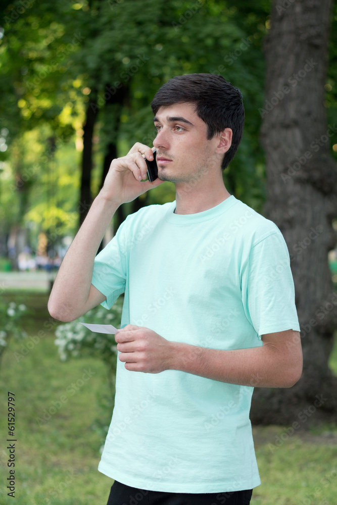 Attractive young guy outdoors calls by telephone Attractive young guy outdoors calls by telephone