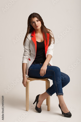 The beautiful young girl poses in studio. Clothes advertizing.
