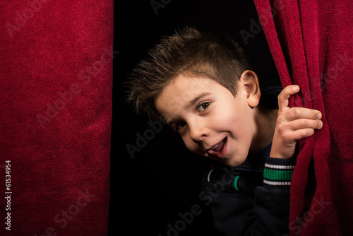 Child appearing beneath the curtain