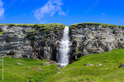 Fototapeta Naklejka Na Ścianę i Meble -  small waterfall coming down from a plateau with a blue sky above