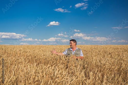 Happy smiling caucasian  old farmer standing in wheat fields © Ryzhkov Oleksandr