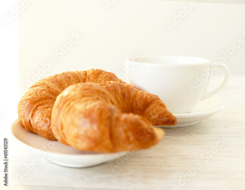 Two croissants and a clean white cup