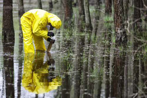 taking sample of water to container in floods contaminated area