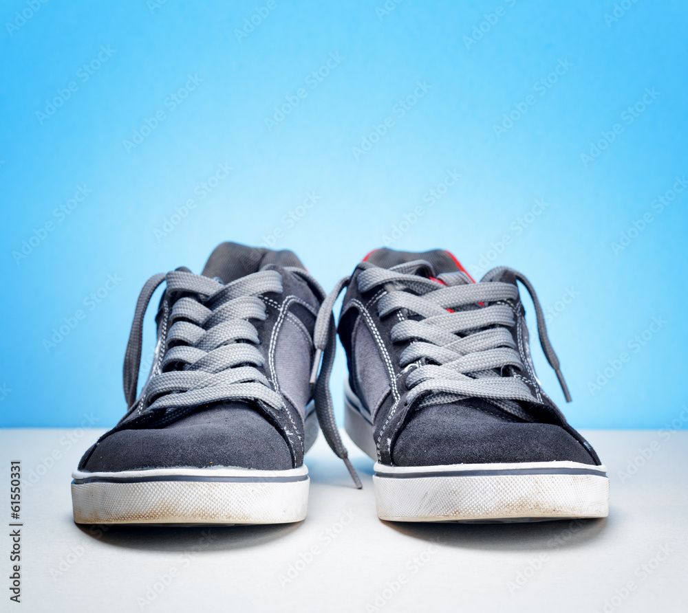 Pair of grey sneakers on colorful background