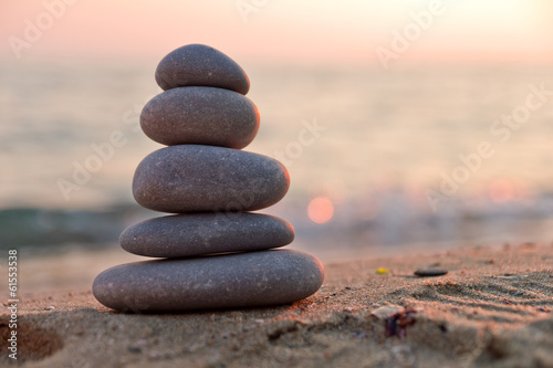 Stacked stones on the beach at sunset
