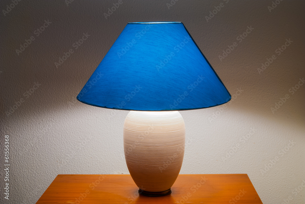 Lit bedside lamp over nightstand Lit bedside lamp over nightstand
