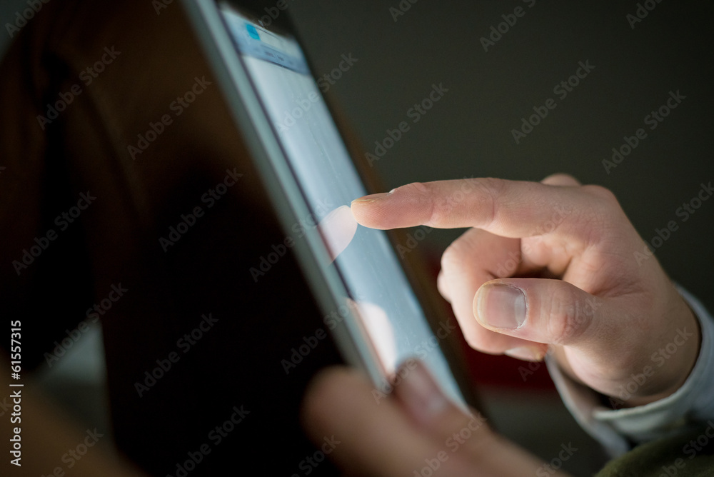 close up of finger touching tablet device close up of finger touching tablet device