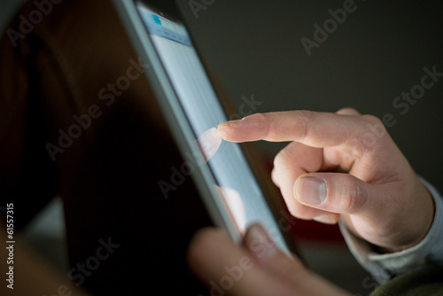 close up of finger touching tablet device
