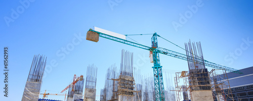 Building crane and construction site under   blue sky