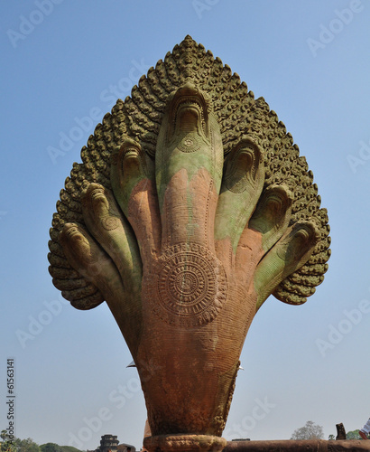 Naga stone statue in front of famous Angkor Wat temple complex,