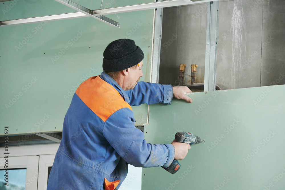 carpenter with gypsum plasterboard and screwdriver carpenter with gypsum plasterboard and screwdriver