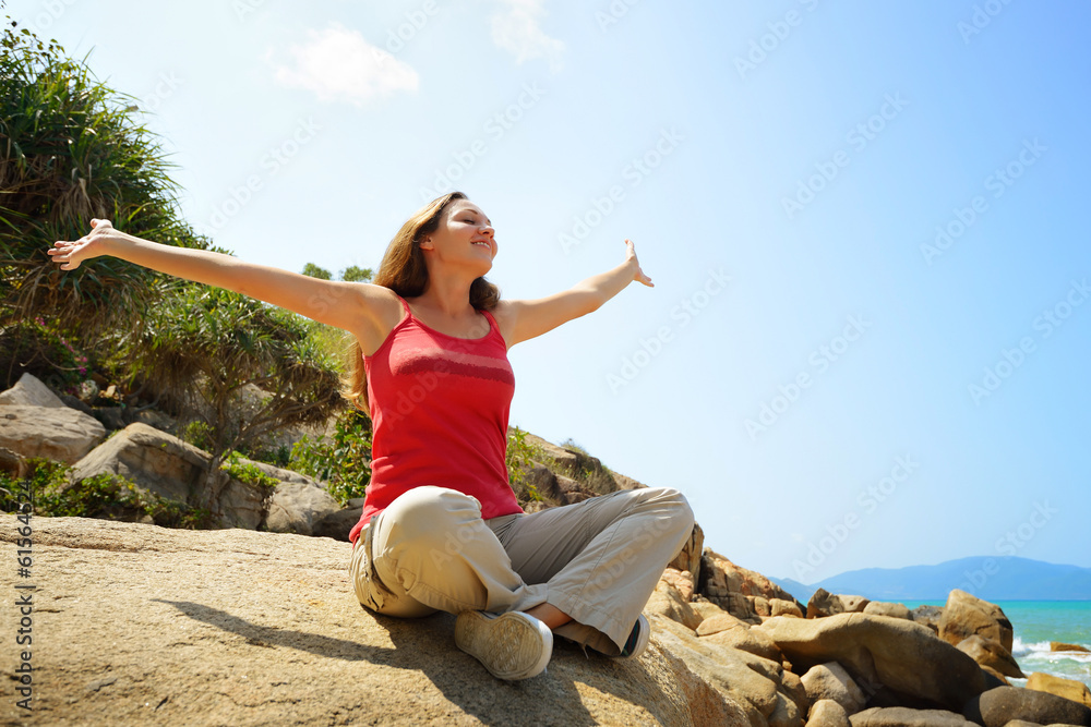 Young woman resting sitting on edge of a cliff. Young woman resting sitting on edge of a cliff.
