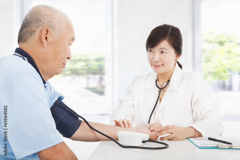 doctor measuring blood pressure of senior man at home doctor measuring blood pressure of senior man at home