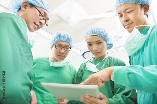 The surgeons useing  tablet  to discuss operating procedure © Tom Wang