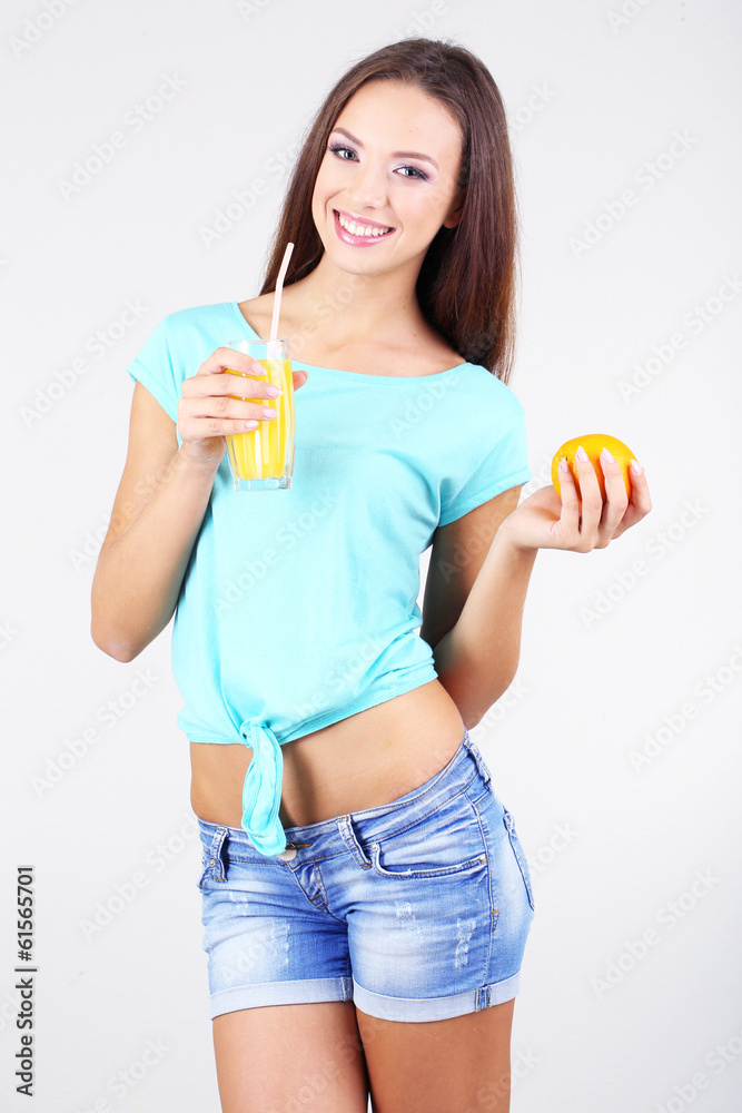Beautiful girl with fresh juice on grey background Beautiful girl with fresh juice on grey background
