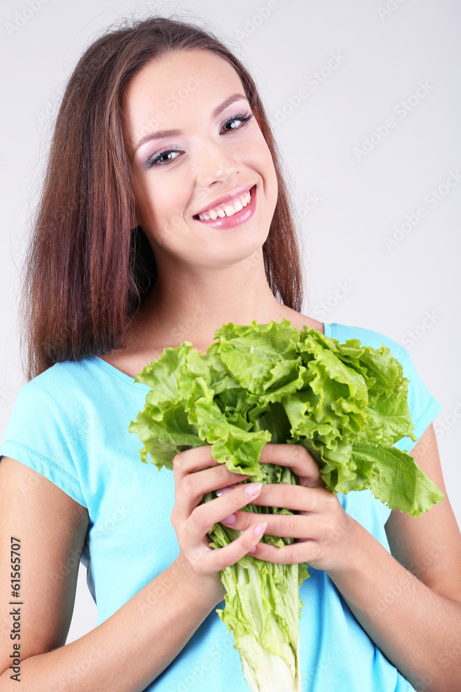 Beautiful girl with fresh salad on grey background Beautiful girl with fresh salad on grey background