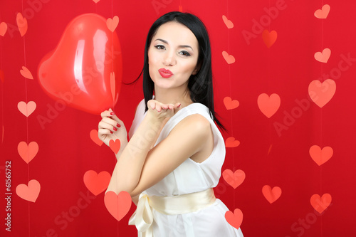 Attractive young woman with balloon on Valentine Day