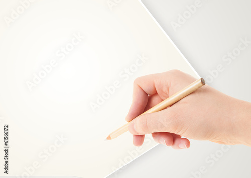 Human hand drawing with pencil on empty paper template