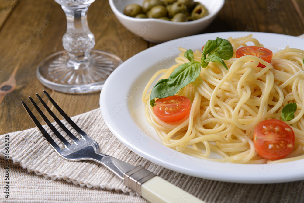 Delicious spaghetti with tomatoes on plate on table close-up Delicious spaghetti with tomatoes on plate on table close-up