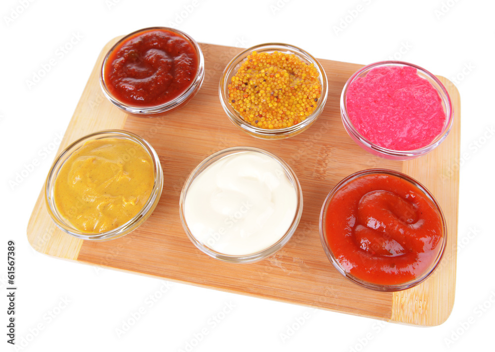 Various sauces on chopping board isolated on white Various sauces on chopping board isolated on white