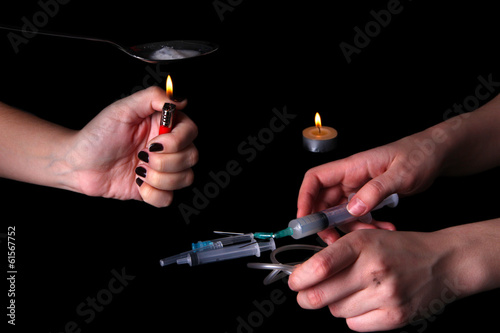 Drug addicts with syringe on black background