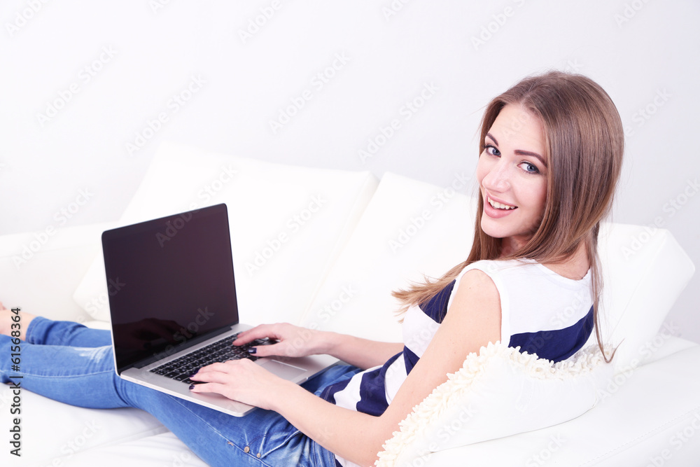 Young woman resting with laptop on sofa at home Young woman resting with laptop on sofa at home