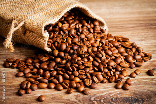 The sack of coffee beans on wooden background
