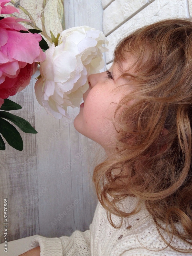 Naklejka premium Beautiful girl smelling flowers