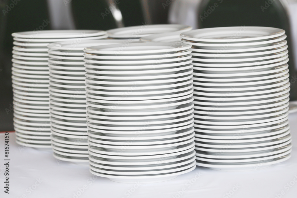 Group of white plates stacked together. Group of white plates stacked together.
