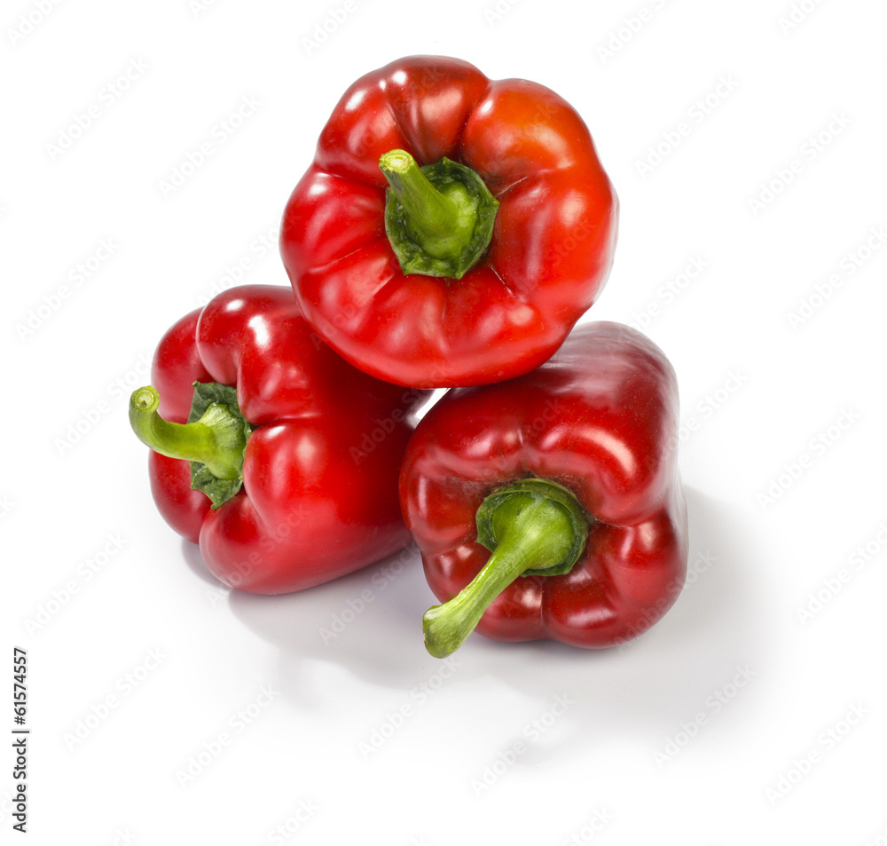 three red peppers on white background
