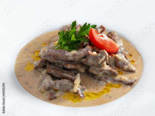 Delicious hot beef stroganoff with cream sauce served on a white