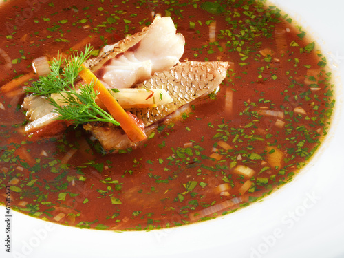Hot delicious tomato soup with fish and rice served with leek an