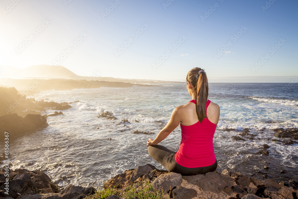 young woman practicing yoga meditation on the beach at sunset young woman practicing yoga meditation on the beach at sunset