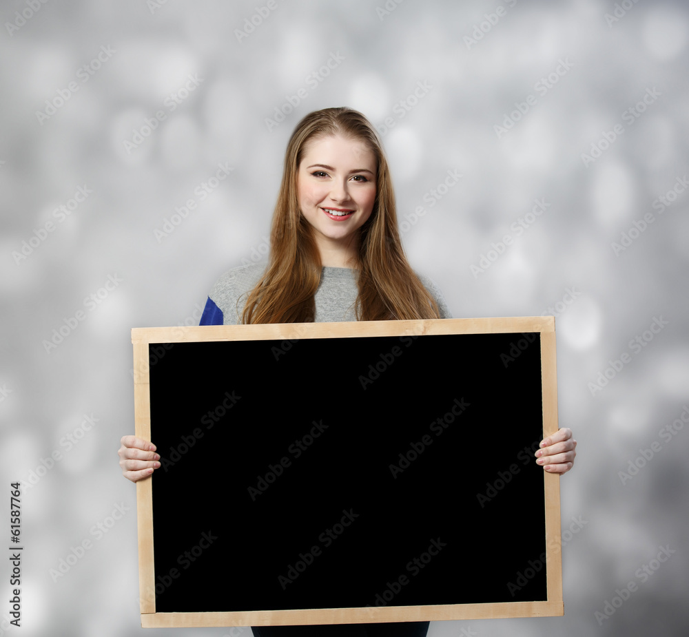 student female holding a chalkboard at light background student female holding a chalkboard at light background